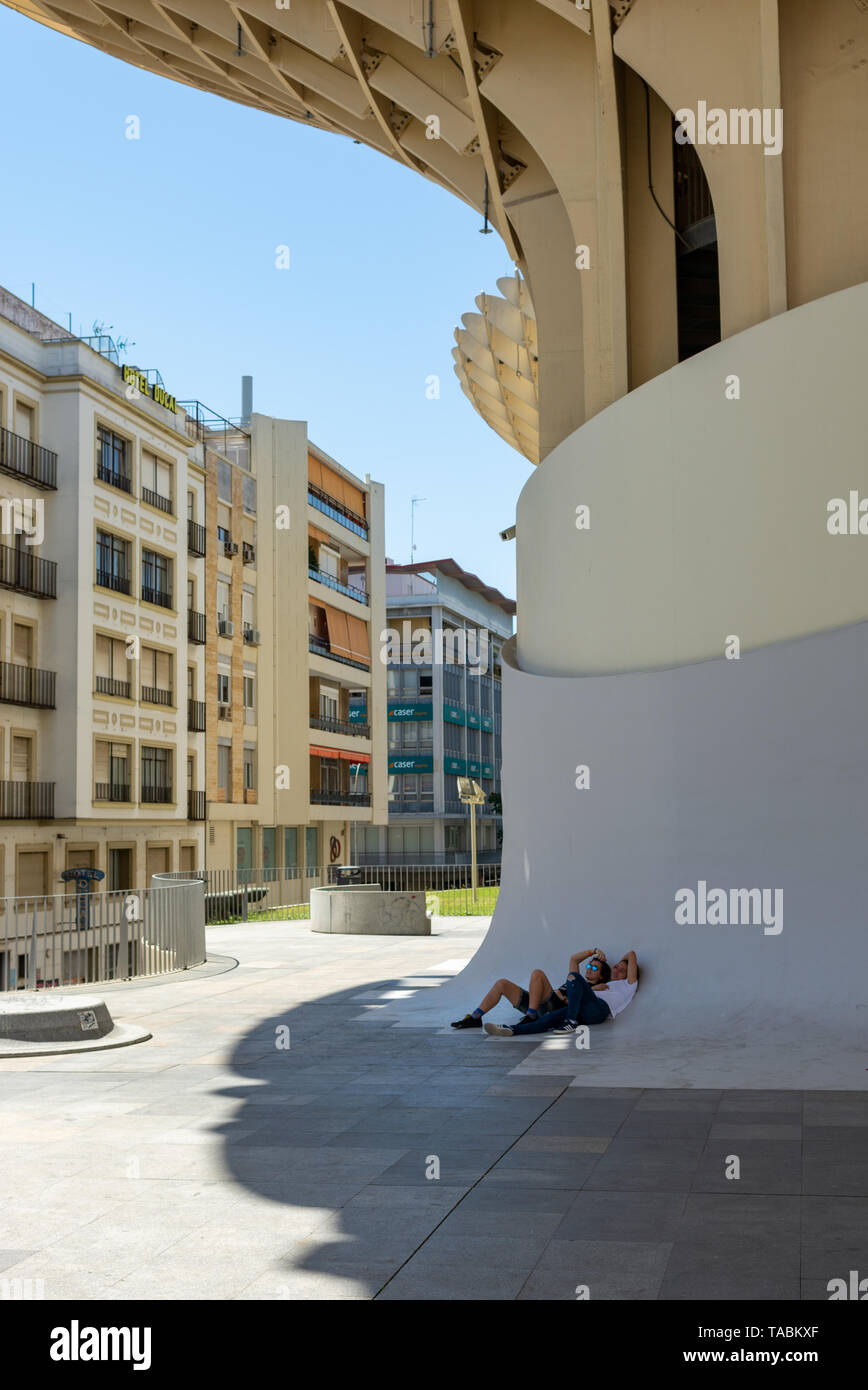 Jeune couple se reposer à l'ombre du Metropol Parasol, Place de La Encarnacion, Séville, Andalousie, Espagne Banque D'Images