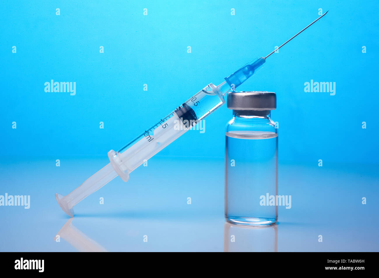 Les vaccins et les médicaments contre la grippe seringue à aiguille sur fond bleu Banque D'Images