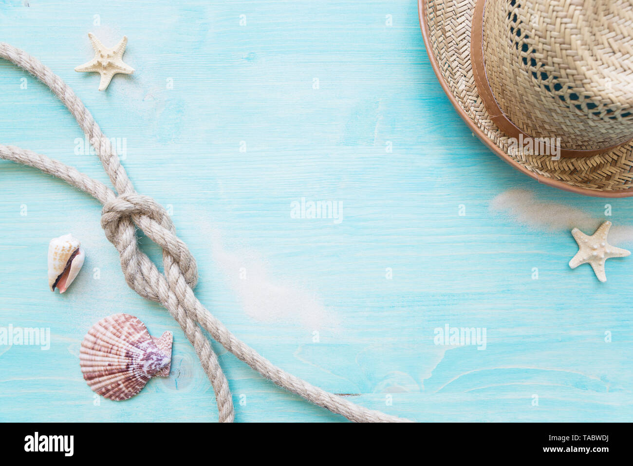 Corde de chanvre brut knot, la mer, des étoiles de hells et chapeau de paille sont sur le fond bleu pâle terrasse en bois. Concept Marine Banque D'Images