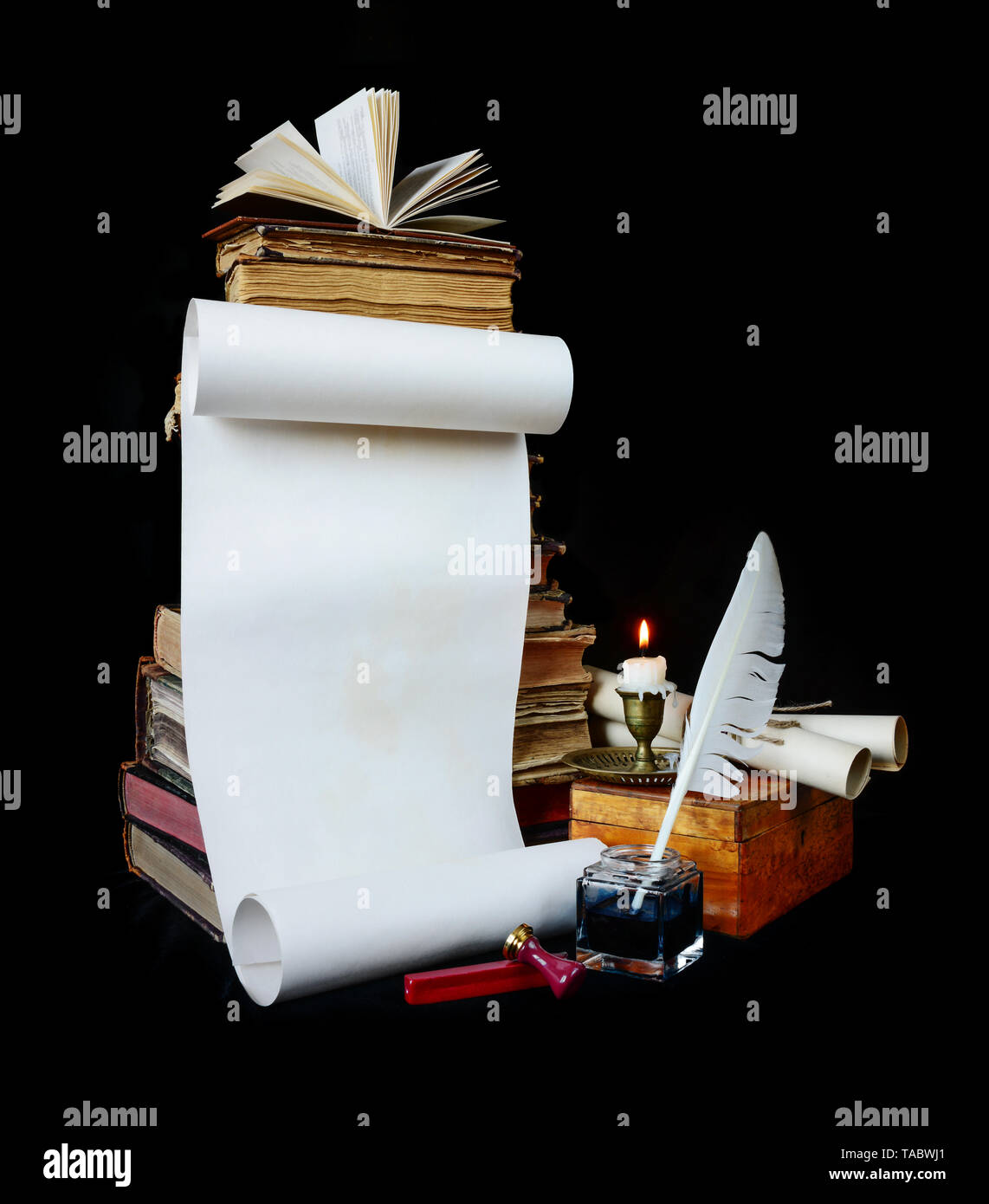 Feuille de papier vierge, en plumes, encrier bougie brûlante en chandelier en cuivre et de vieux livres isolé sur fond noir, avec l'espace pour le texte Banque D'Images
