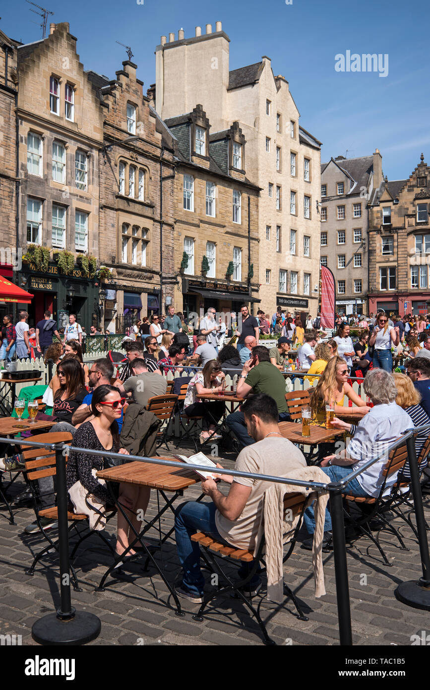 Les touristes et habitants de manger dehors et profiter de certains au début de l'été soleil dans le Grassmarket, Édimbourg, Écosse, Royaume-Uni. Banque D'Images