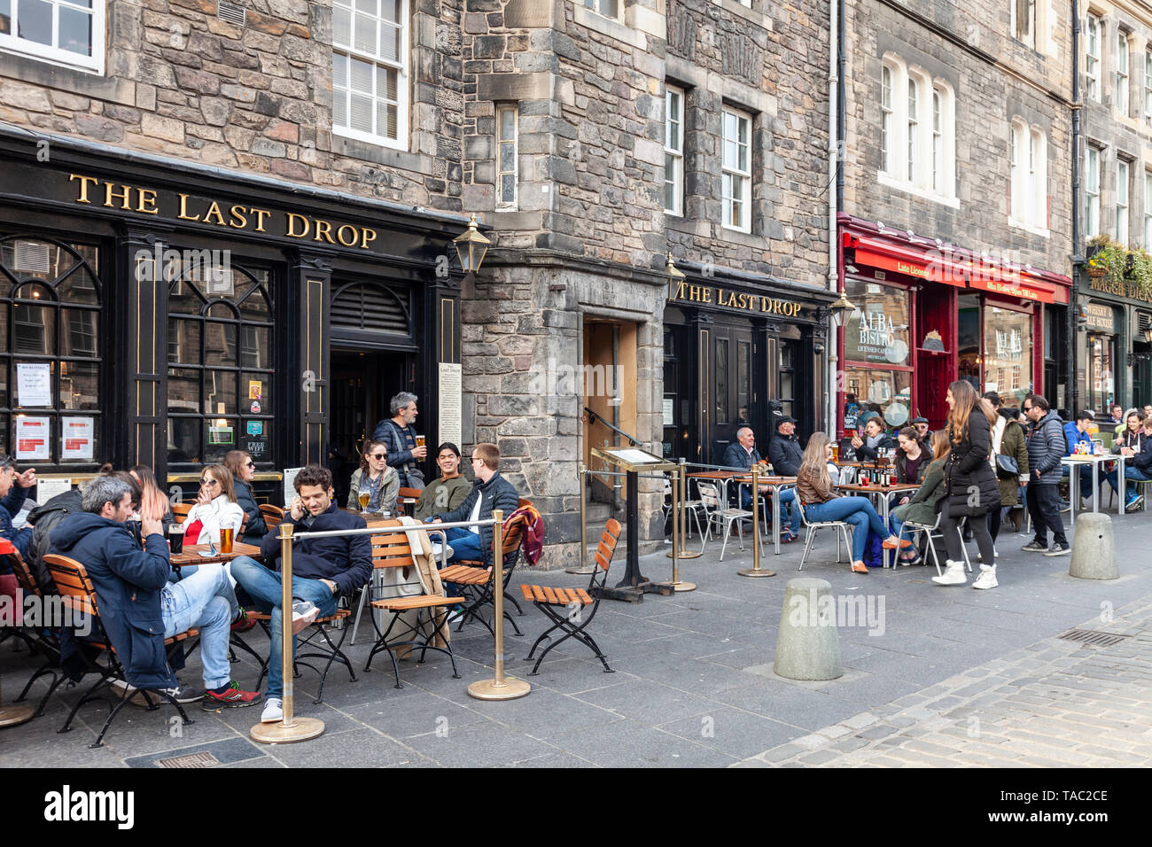 Les clients se détendre dans la utdoor assis dehors la dernière goutte pub dans le Grassmarket de la vieille ville d'Édimbourg, Écosse, Royaume-Uni Banque D'Images