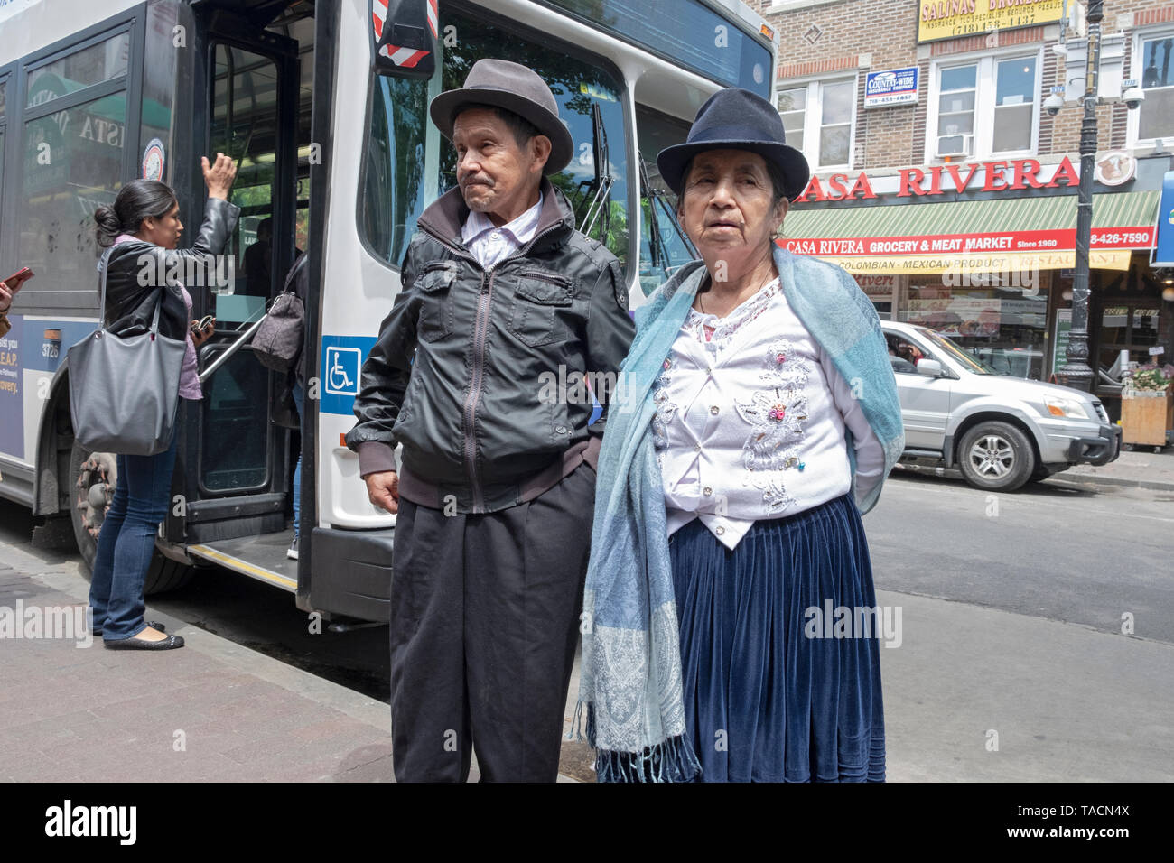 Un couple qui semblent être les immigrés mexicains d'attendre à l'extérieur un tore sur la 82e Rue à Jackson Heights, Queens, New York. Banque D'Images