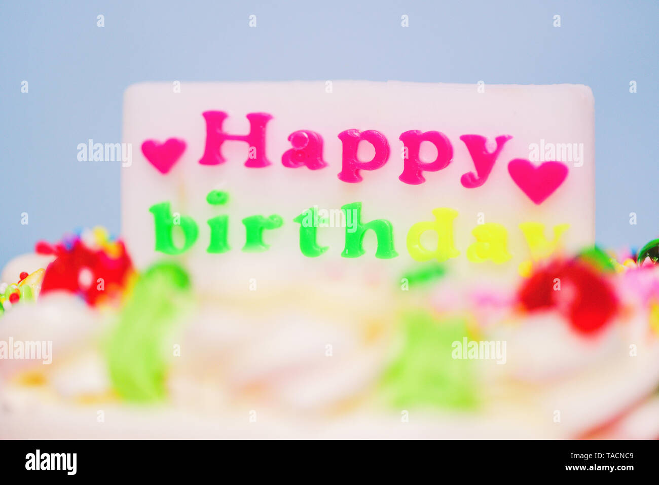 Gâteau d'anniversaire coloré avec étiquette de joyeux anniversaire et en forme d'coeur Close up Banque D'Images