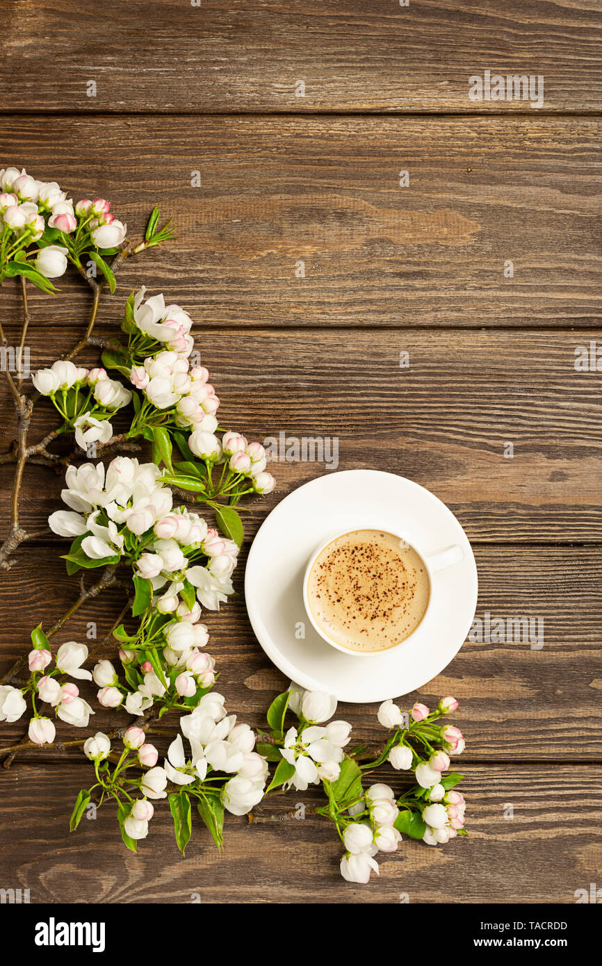Une tasse de café aromatique et une branche d'un pommier sur un fond de bois. Télévision mise en page. Banque D'Images