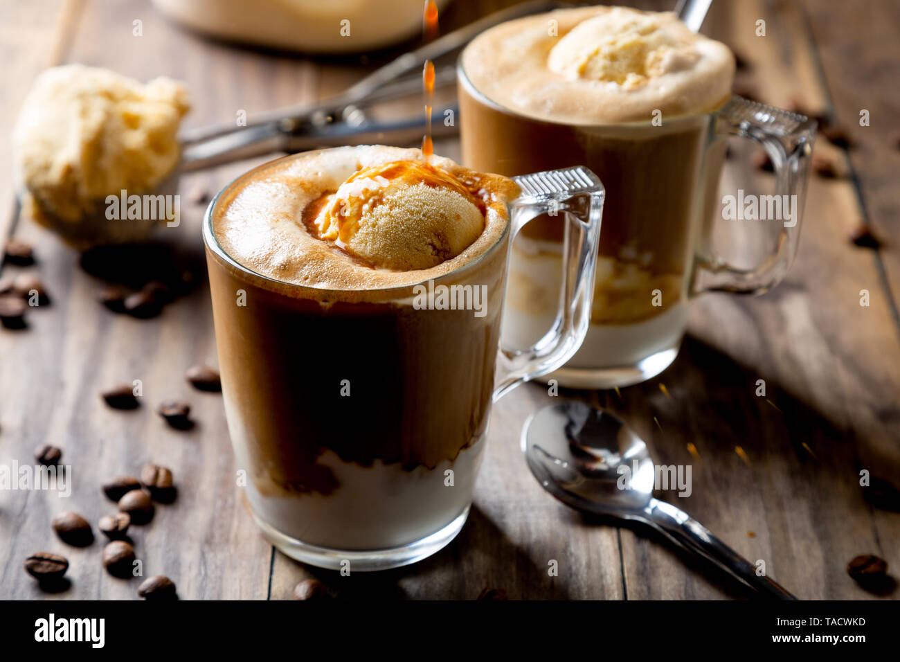 Verser du café sur la glace à la vanille pour faire un affogato café sur une table en bois rustique Banque D'Images Verser du café sur la glace à la vanille pour faire un affogato café sur une table en bois rustique Banque D'Images