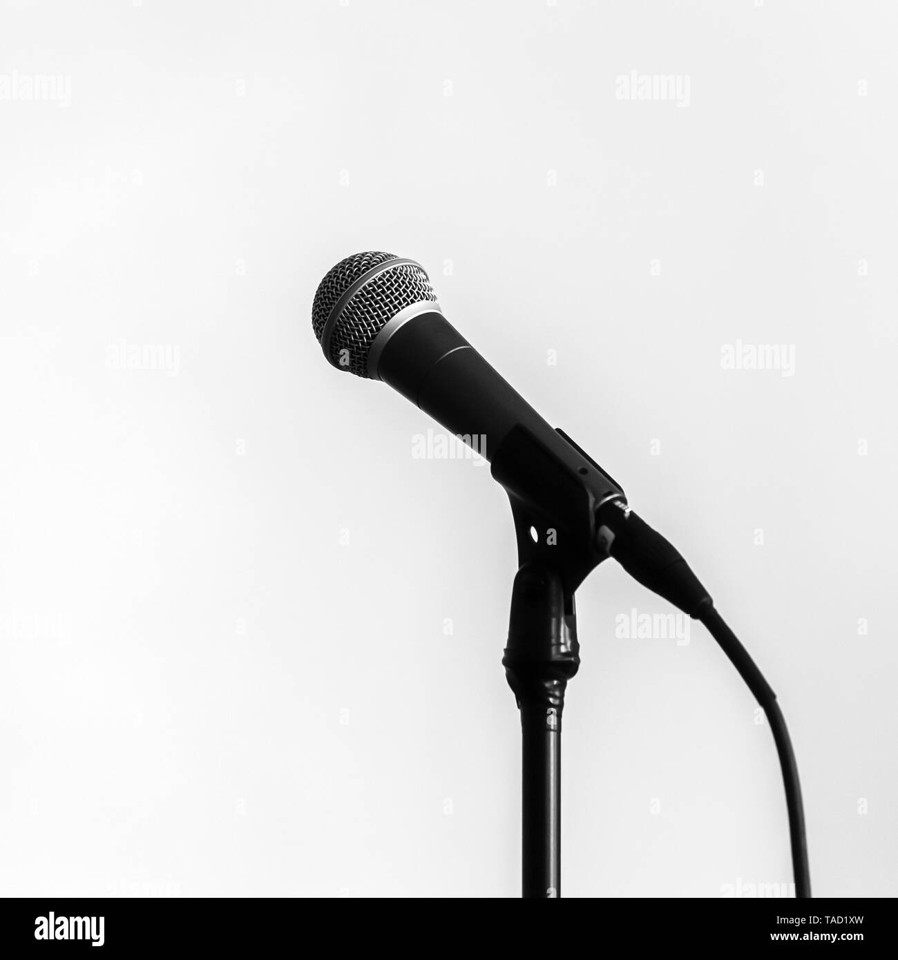 Microphone avec câble noir sur fond blanc, square photo Banque D'Images