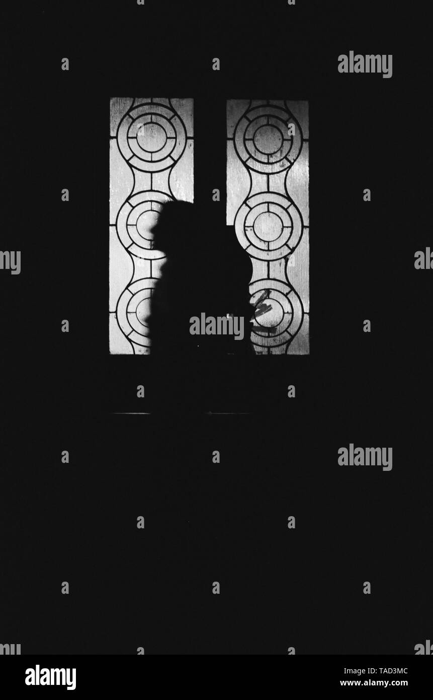 Un homme passe devant une fenêtre à motifs à La Havane, Cuba Banque D'Images