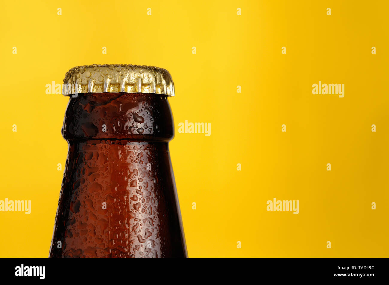 Bouteille de bière avec un couvercle sur le fond jaune Banque D'Images