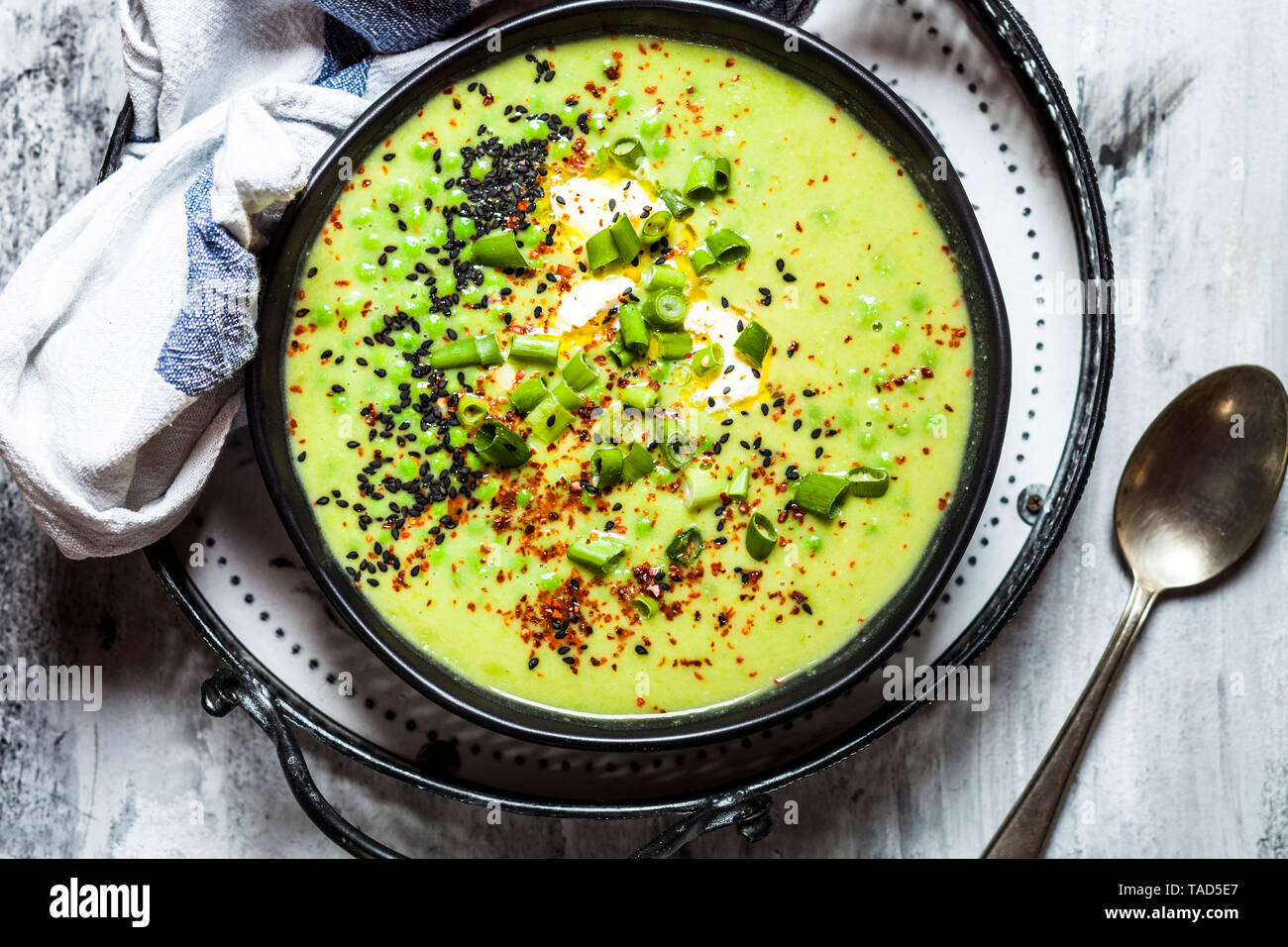 Bol de soupe aux pois verts frais avec des oignons de printemps Banque D'Images