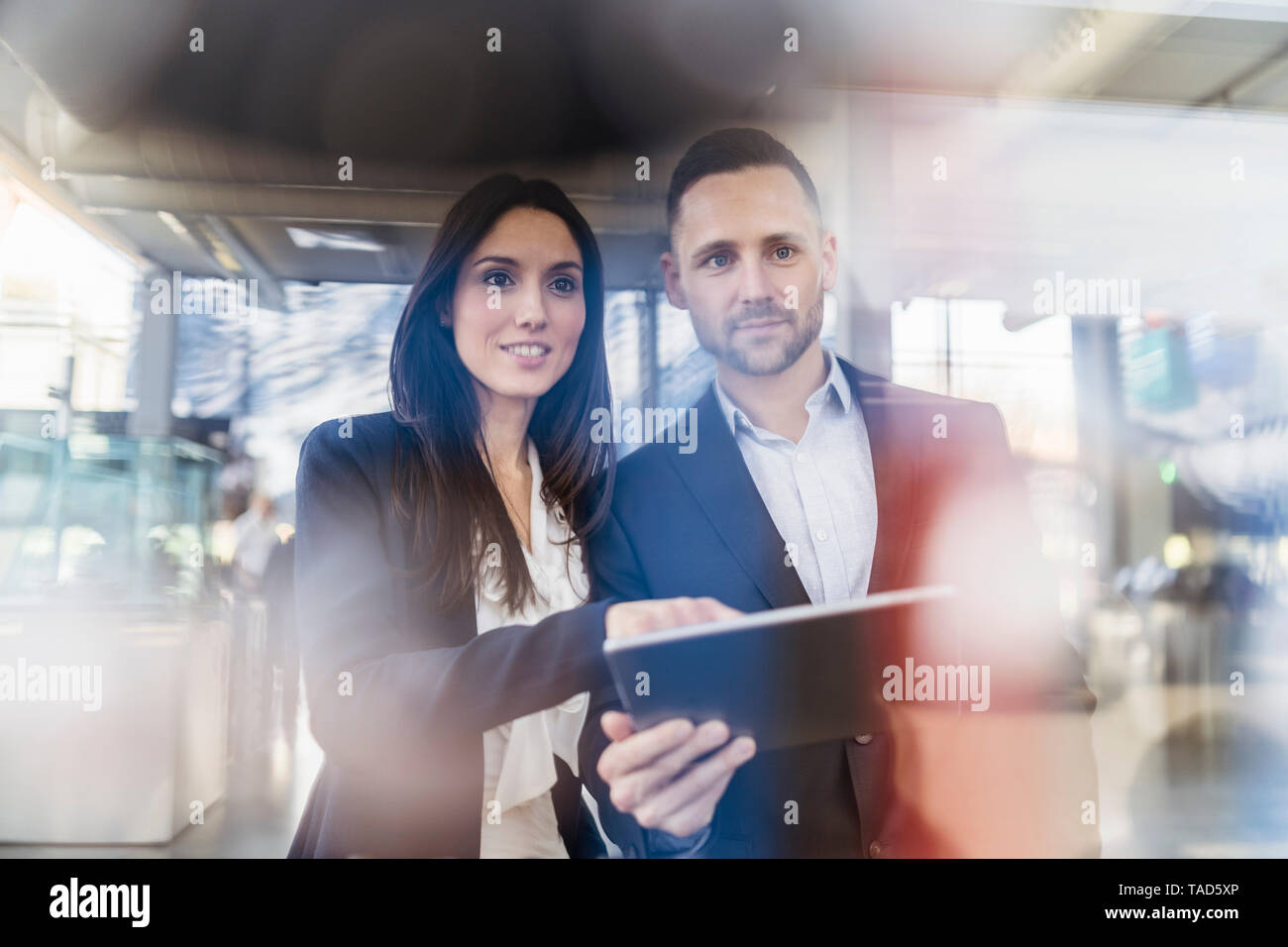 Smiling businessman and businesswoman with tablet à à une machine dans l'usine moderne Banque D'Images