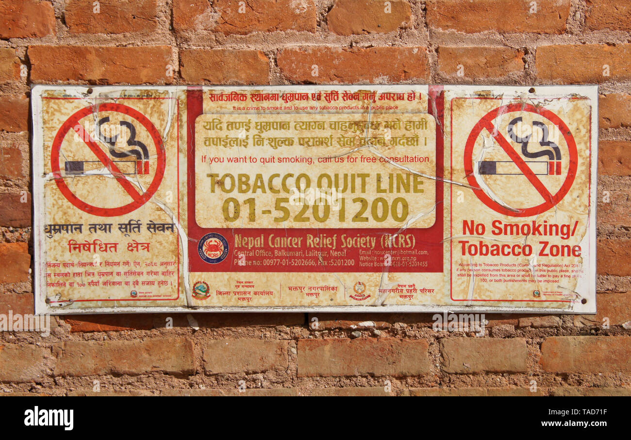 Le bilinguisme (anglais et Népalais) 'non fumeurs' signer sur mur de brique dans Bhaktapur, Vallée de Katmandou, Népal Banque D'Images