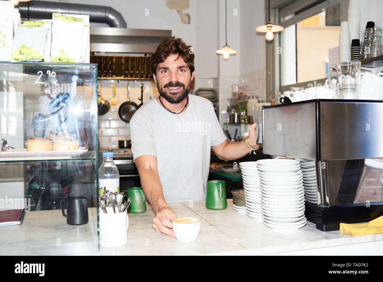Portrait of smiling barista au comptoir d'un café Banque D'Images