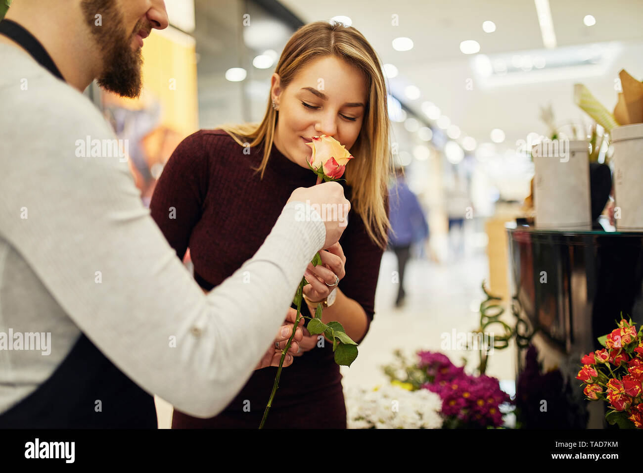 Laisser fleuriste fleurs à odeur client in flower shop Banque D'Images