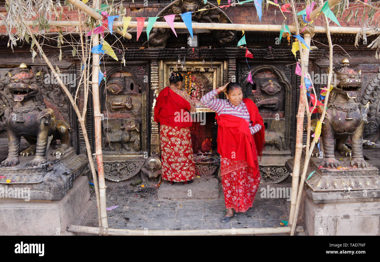 Adorant les femmes dans de petits sanctuaire hindou à la base de Bhairabnath Mandir, Taumadhi Tol, Bhakatapur, Vallée de Katmandou, Népal Banque D'Images
