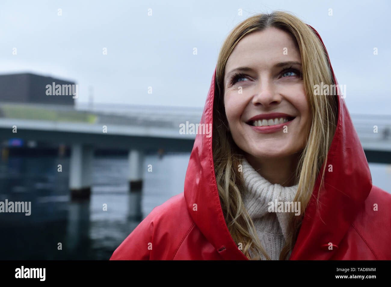 Danemark, copenhague, portrait de femme heureuse au bord de l'eau par temps de pluie Banque D'Images