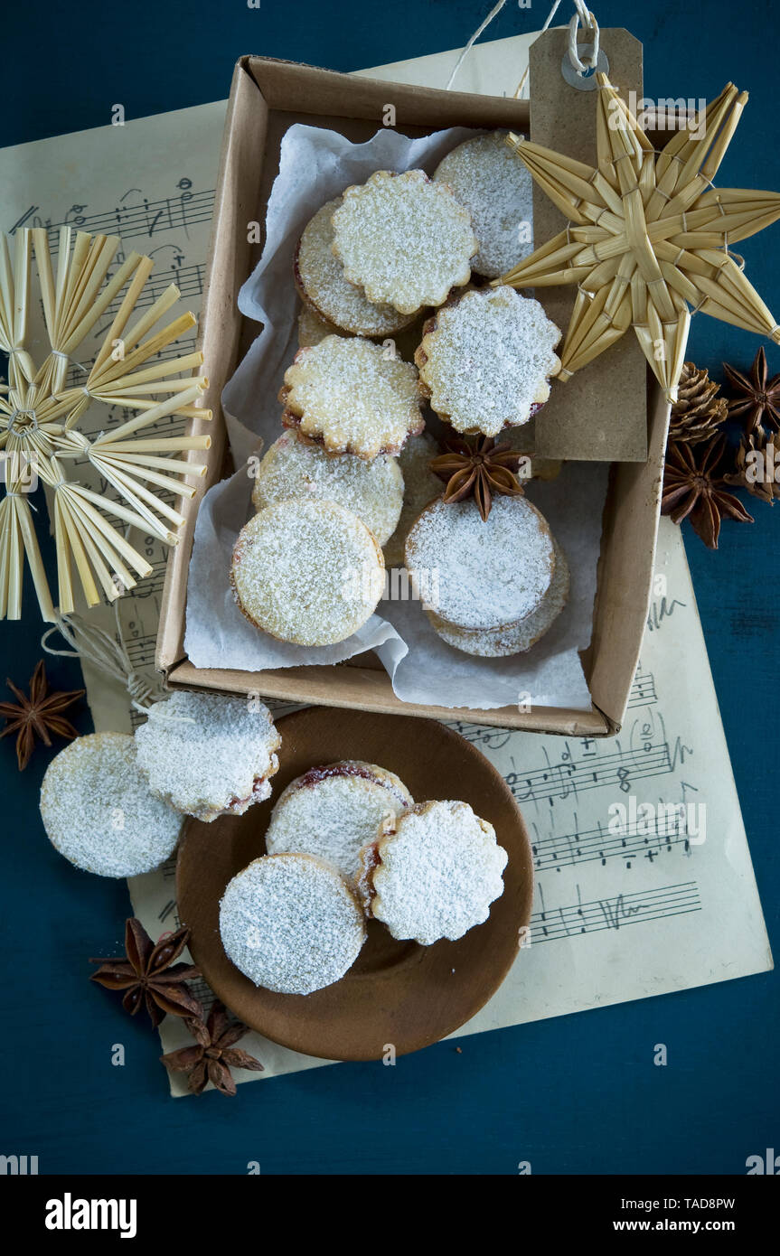 Cookies de Noël Spitzbuben dans une boîte, feuille de musique, la paille étoile, l'anis étoilé, les cônes de mélèze, gift tag Banque D'Images