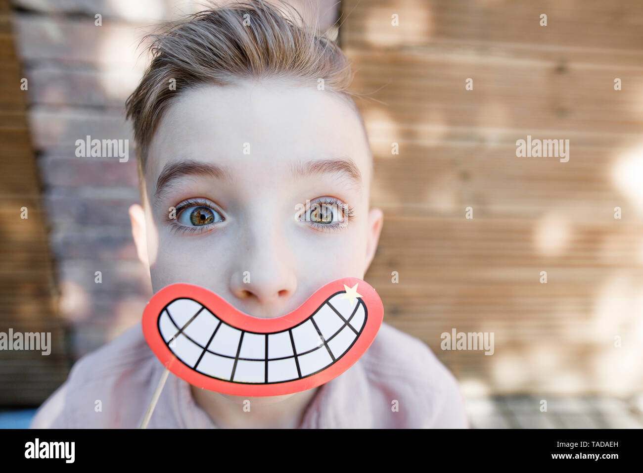 Garçon Blond souriant avec masque bouche Banque D'Images