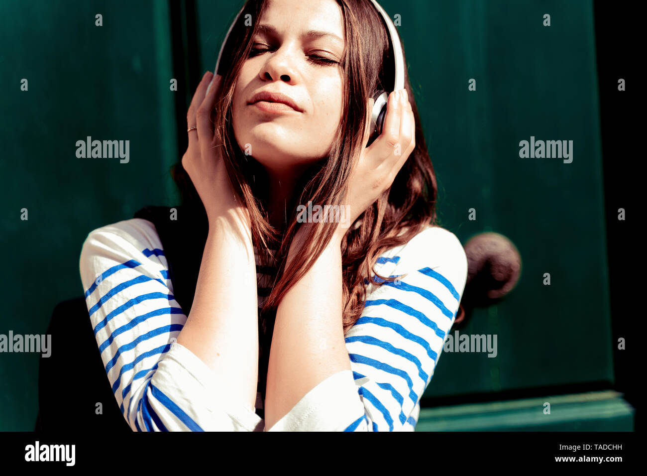 Jeune femme à l'écoute de la musique avec les yeux fermés Banque D'Images