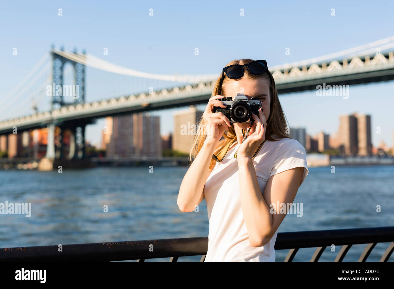 Jeune femme d'explorer la ville de New York, prenez des photos de pont de Brooklyn Banque D'Images