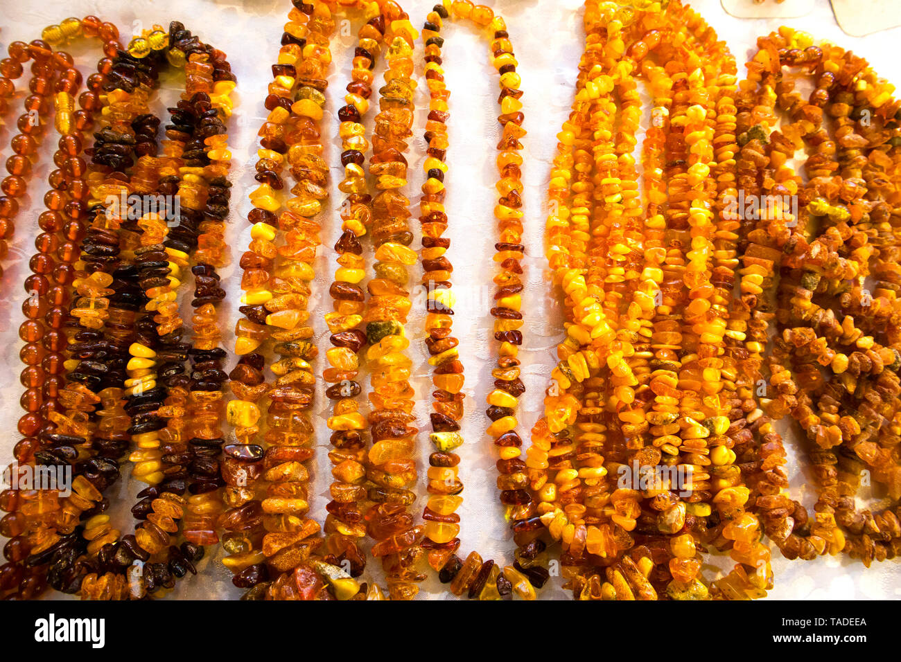 Pierre de Soleil, un certain nombre d'ambre colliers et poignets disposés sur une nappe blanche Banque D'Images