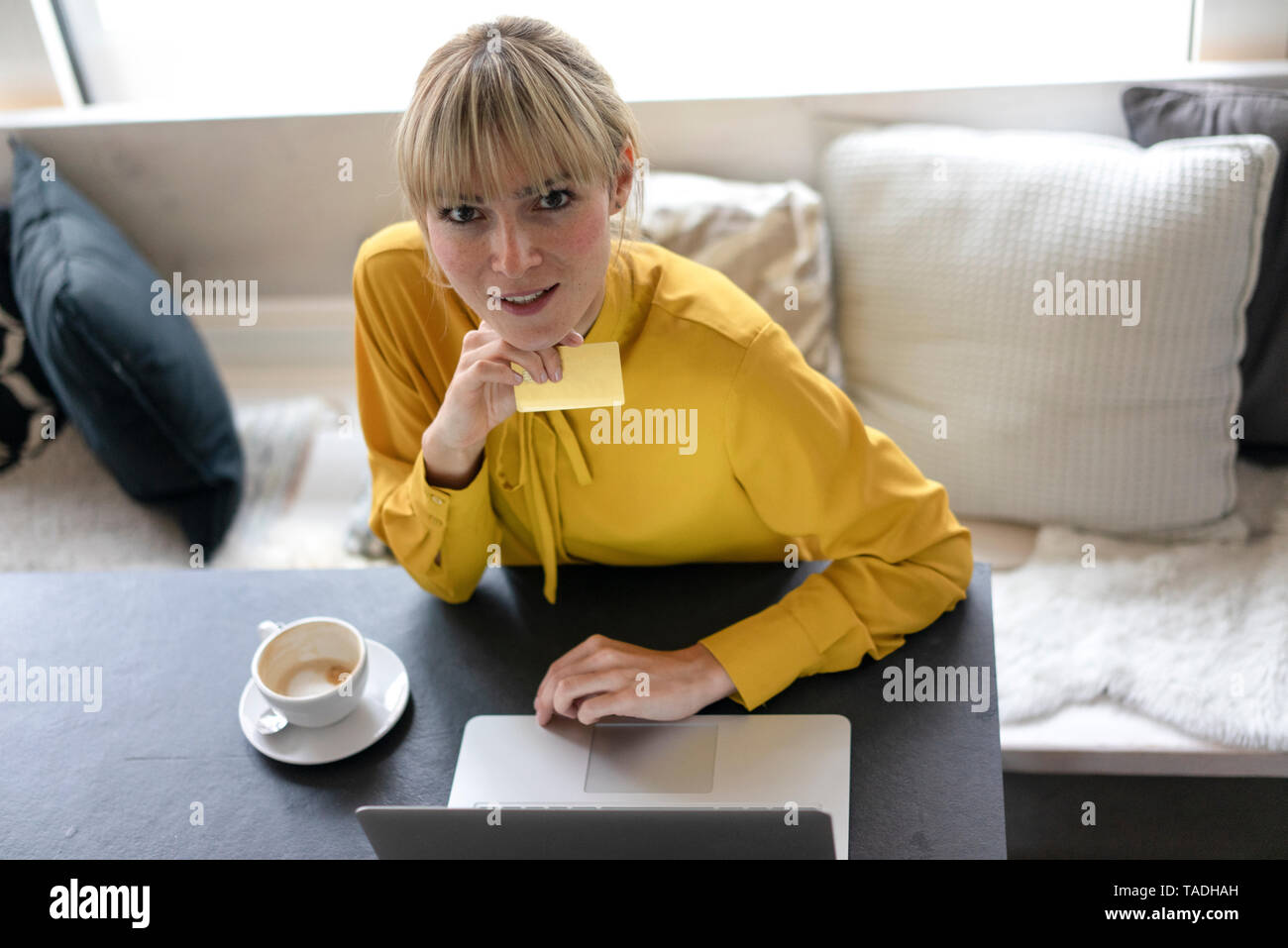 Femme blonde faire le paiement en ligne avec sa carte de crédit Banque D'Images