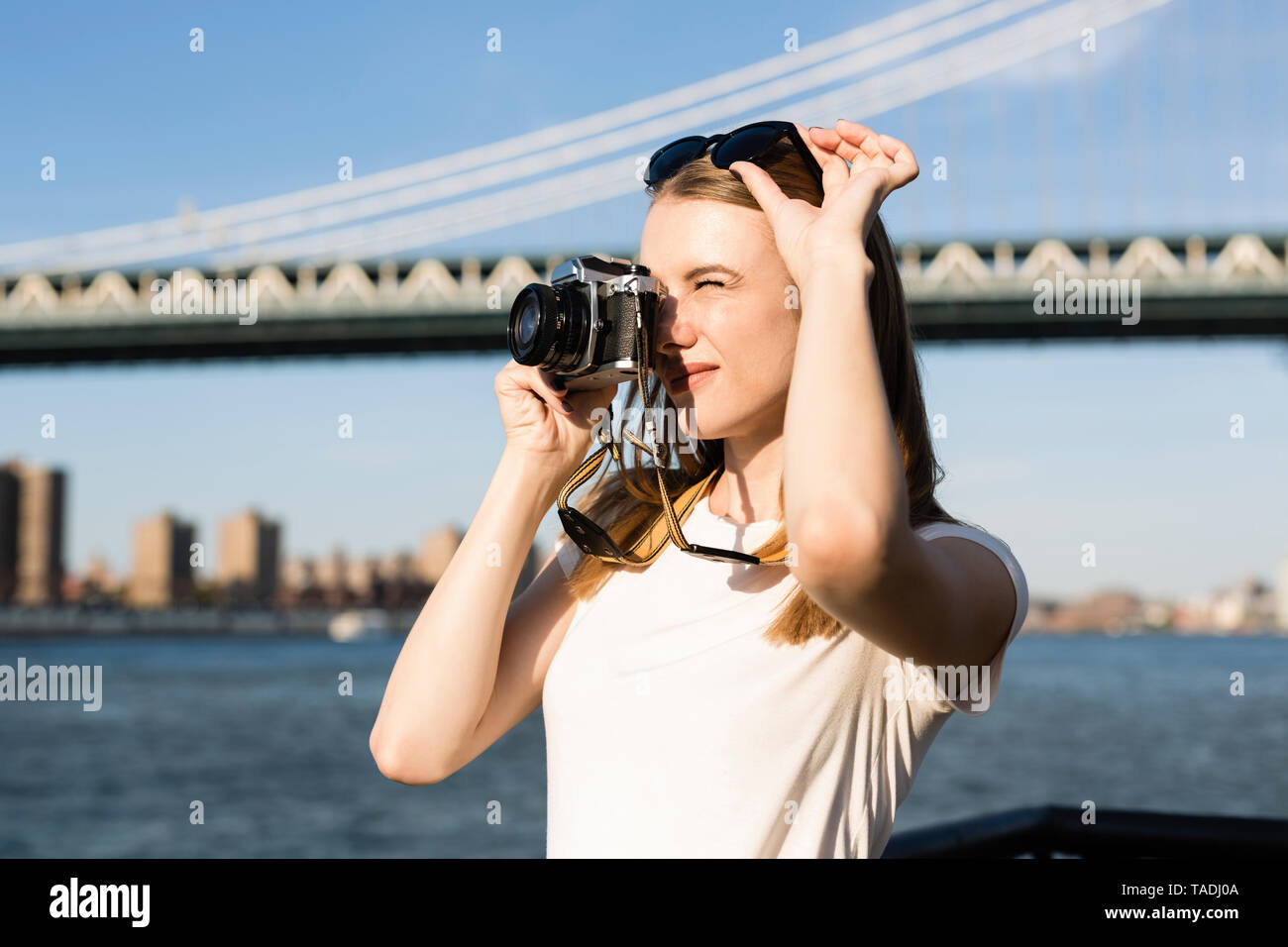 Jeune femme d'explorer la ville de New York, prenez des photos de pont de Brooklyn Banque D'Images