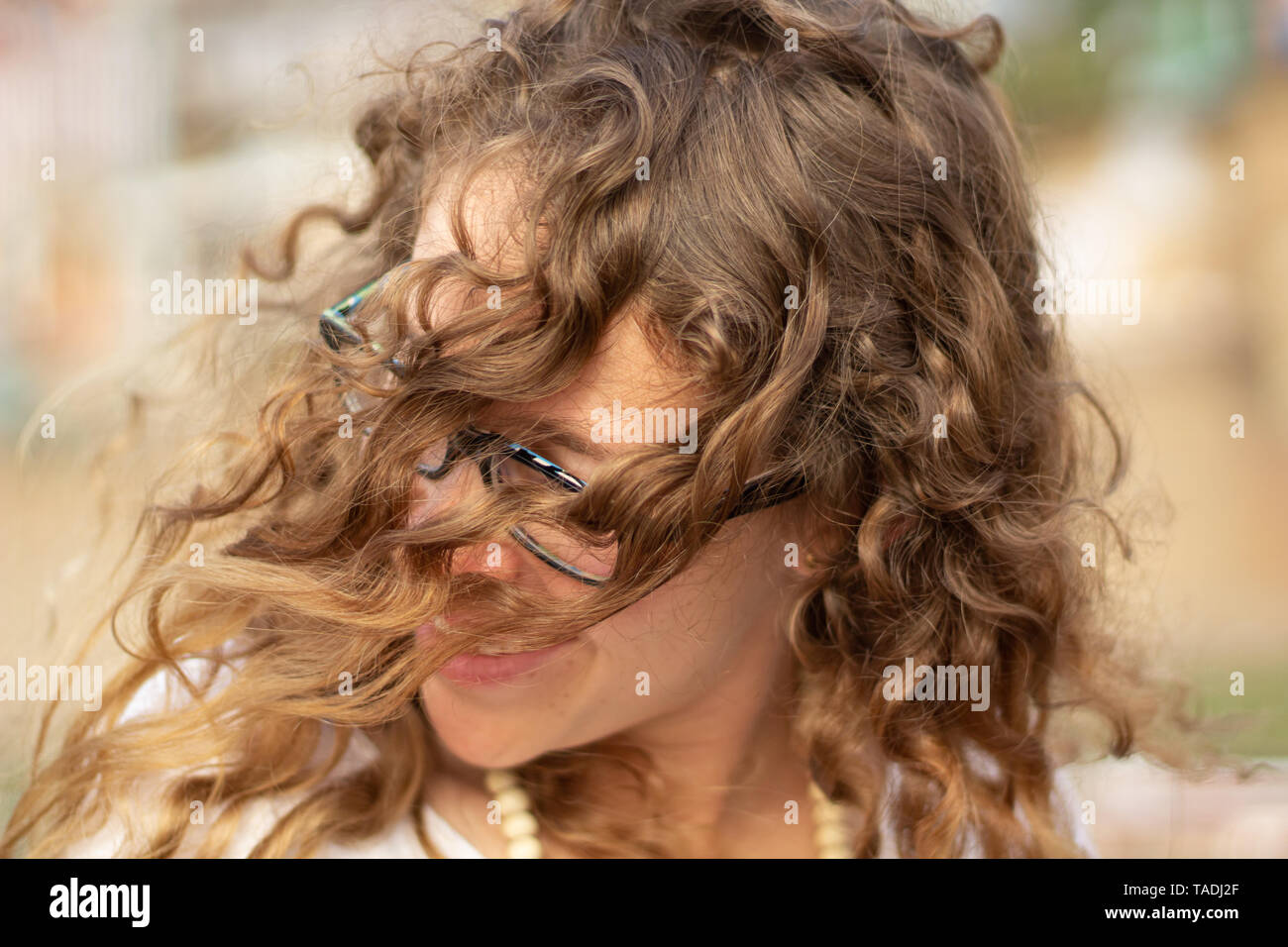Jeune femme blonde avec des boucles de profiter de la vie contre le vent. Banque D'Images