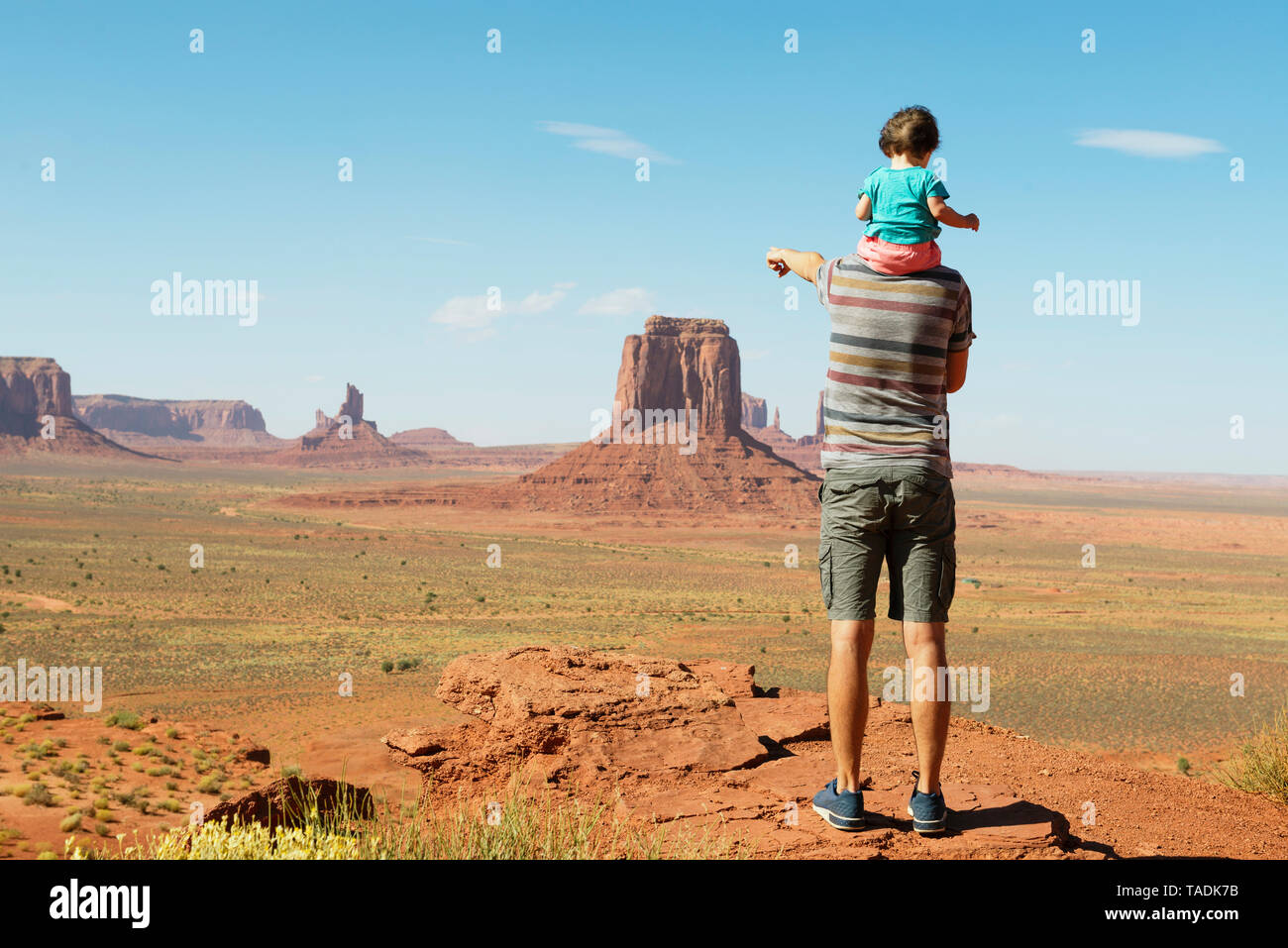 USA, Utah, Monument Valley, le père qui voyage avec bébé, fille sur les épaules et se dirigeant à Monument Valley landscape Banque D'Images