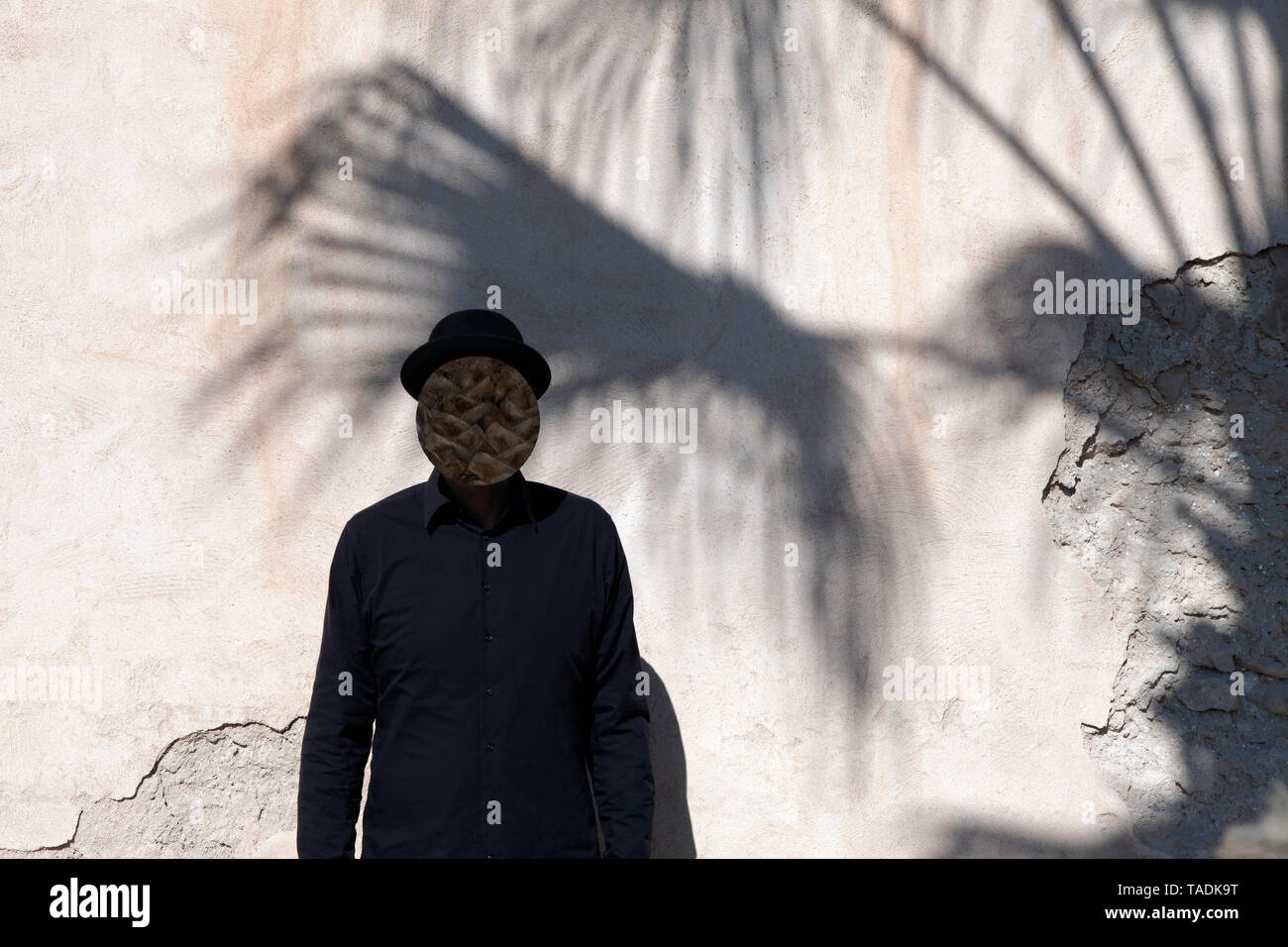 Maroc, Essaouira, avec l'homme masqué face portant un chapeau melon à un mur Banque D'Images