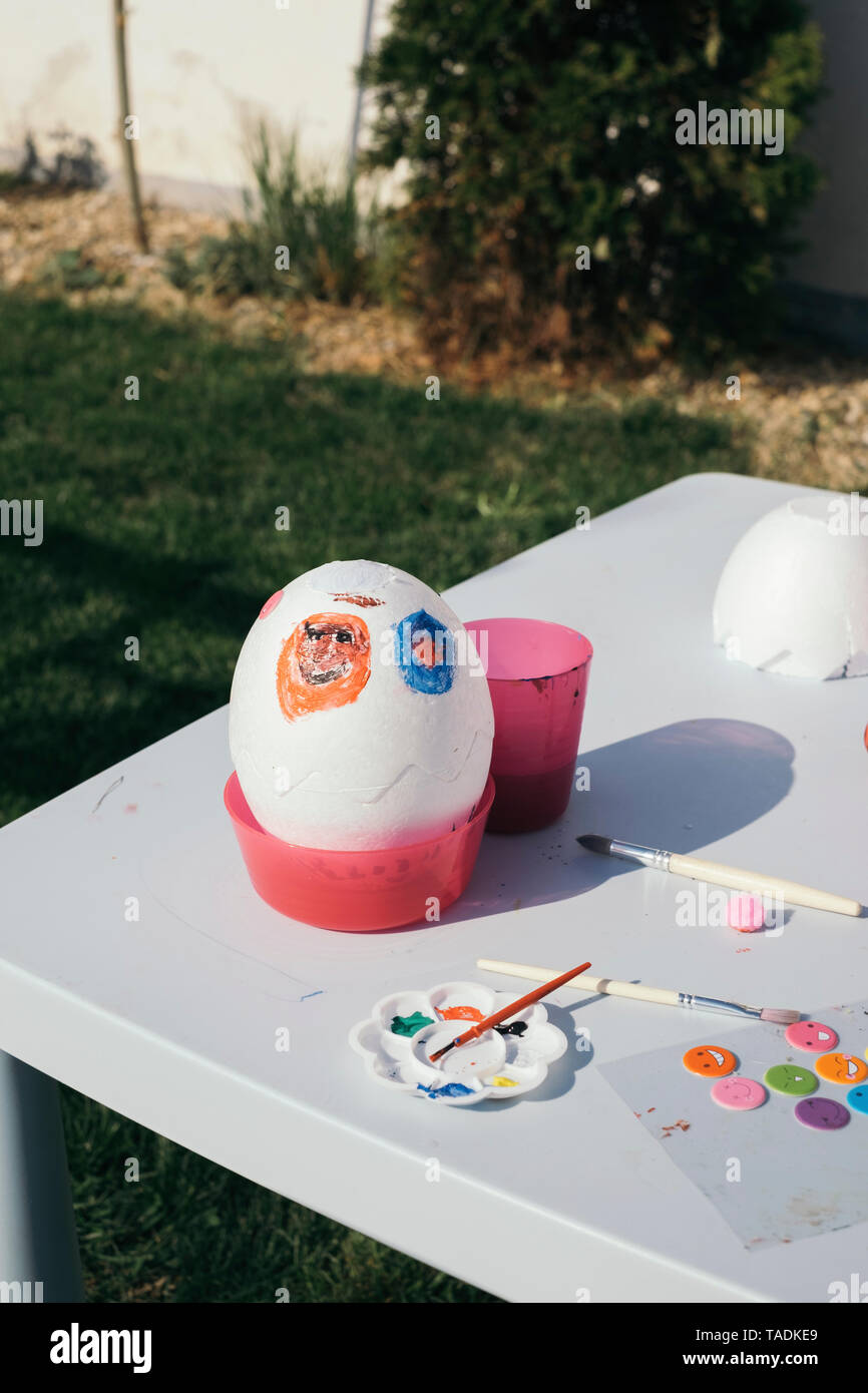 Kid's painted easter egg in garden Banque D'Images