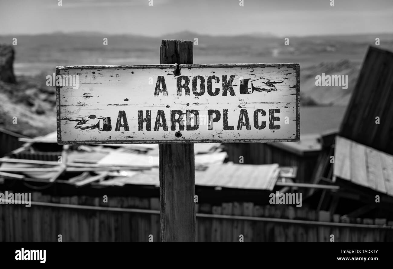 Entre un rocher et un panneau de direction du désert de Hard place Banque D'Images