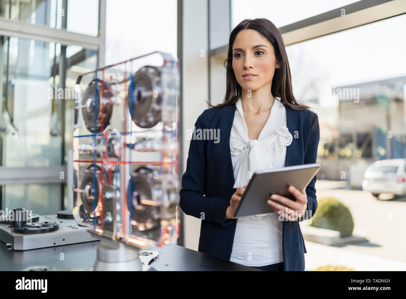 Businesswoman with tablet à la machine à dans une usine moderne Banque D'Images