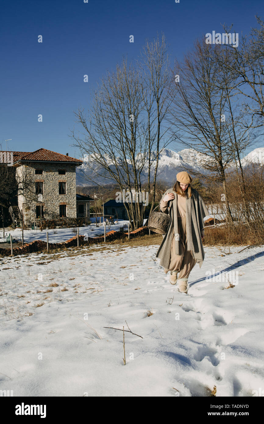 Femme avec panier marchant dans la neige paysage de covefred Banque D'Images