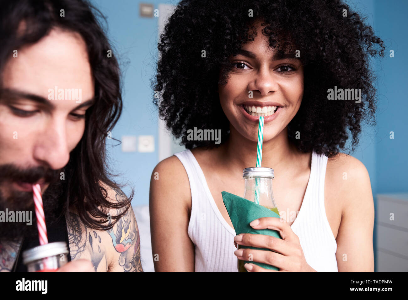 Portrait of smiling young woman with boyfriend smoothie potable Banque D'Images