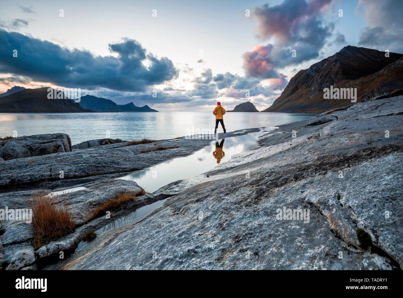 La Norvège, îles Lofoten, Haukland Beach, randonneur debout sur rock Banque D'Images