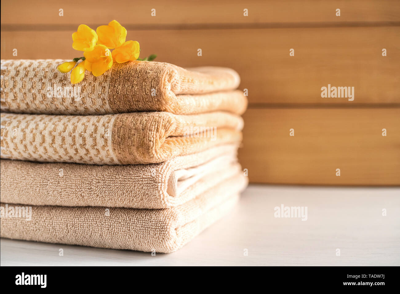 Pile de serviettes beiges sur fond de bois. Banque D'Images