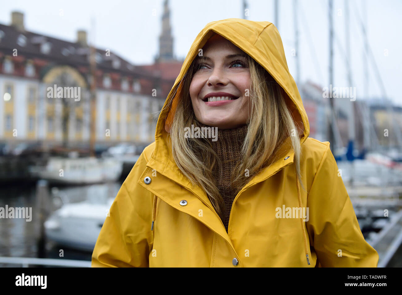 Danemark, copenhague, portrait de femme heureuse au port de la ville par temps de pluie Banque D'Images