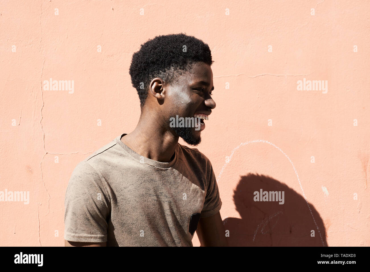 Portrait of a young man laughing outdoors Banque D'Images