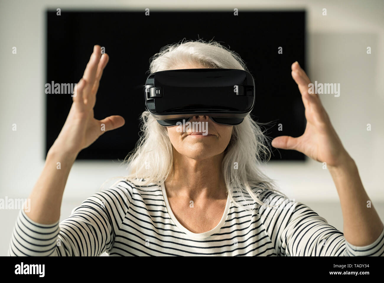 Portrait of mature woman using Virtual Reality Lunettes à la maison Banque D'Images