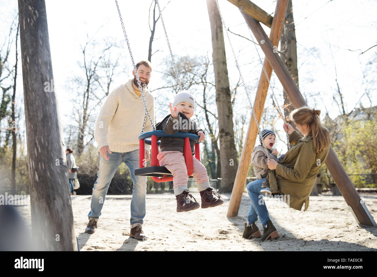 Famille heureuse sur l'aire de jeux Banque D'Images