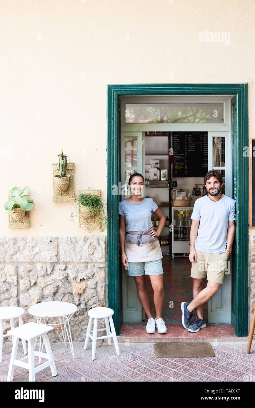 Portrait of a man and woman standing à porte d'entrée d'un café Banque D'Images