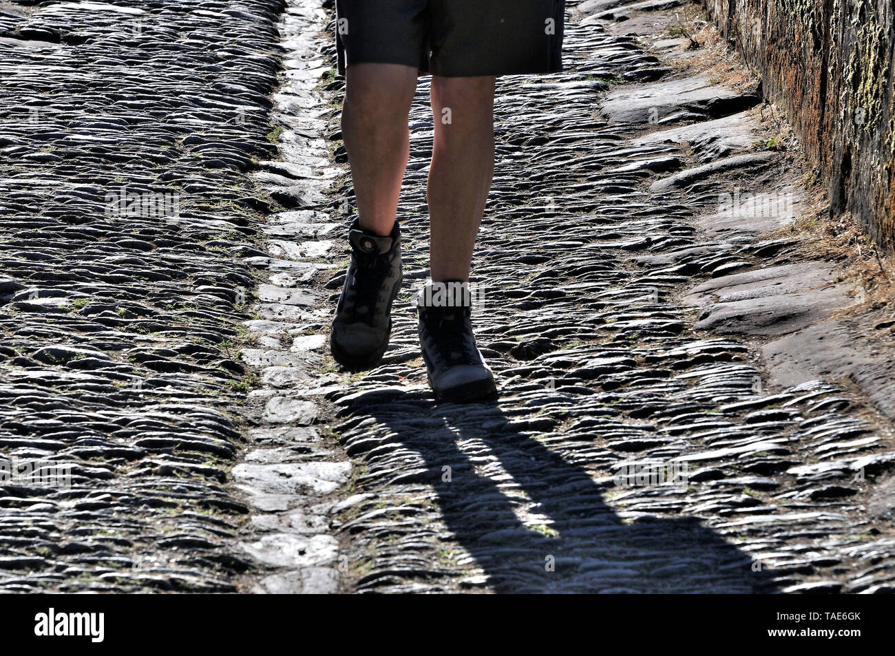 Randonneur arrivant à Conques, dans le département de l'Averon , Chemin de Saint Jacques (Santiago de Compostela), Òvoie PuyÓ du chemin, la France. Chaussures de randonnée sur le Banque D'Images