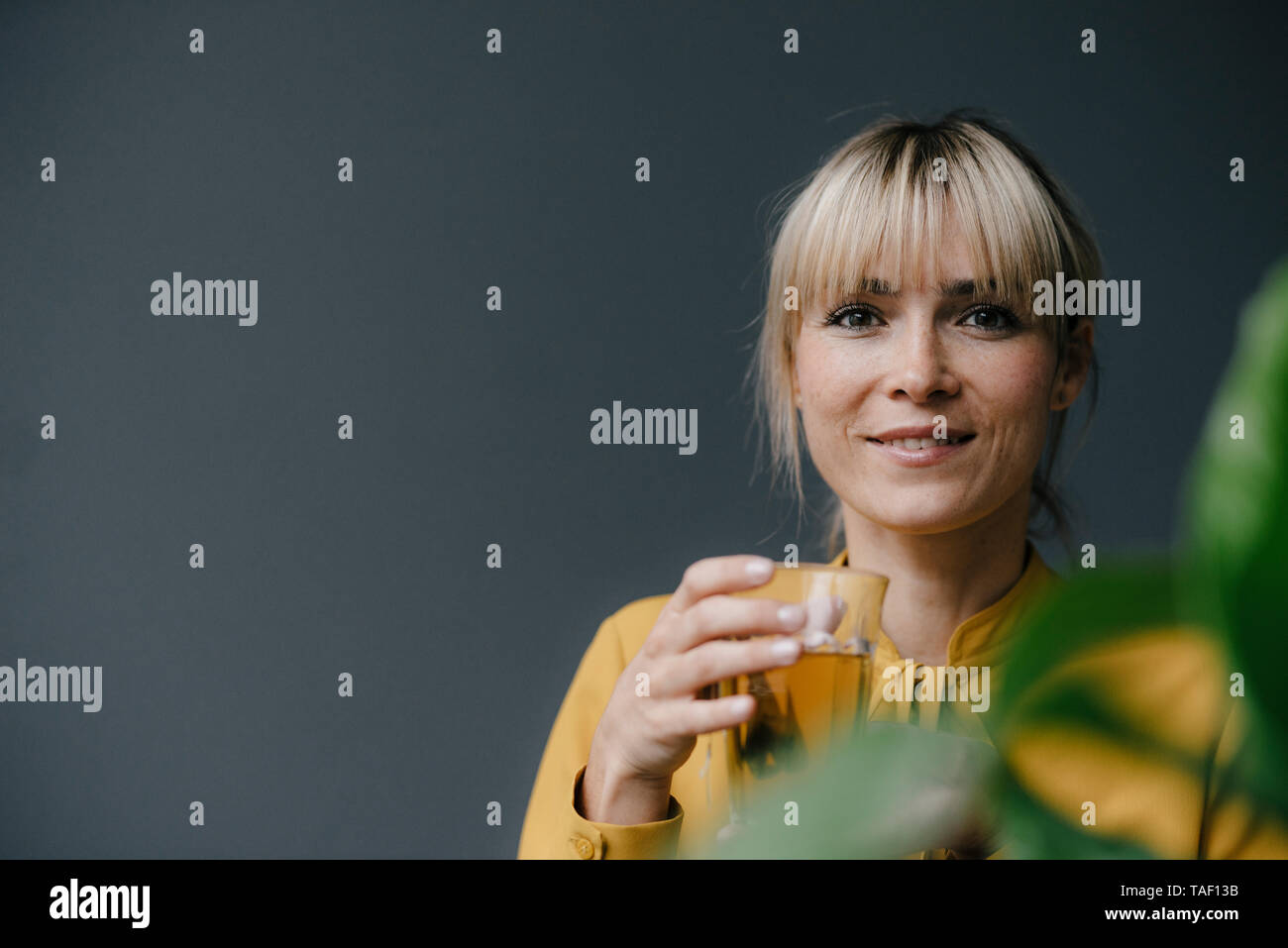 Portrait d'une belle femme blonde, de boire du thé glacé Banque D'Images