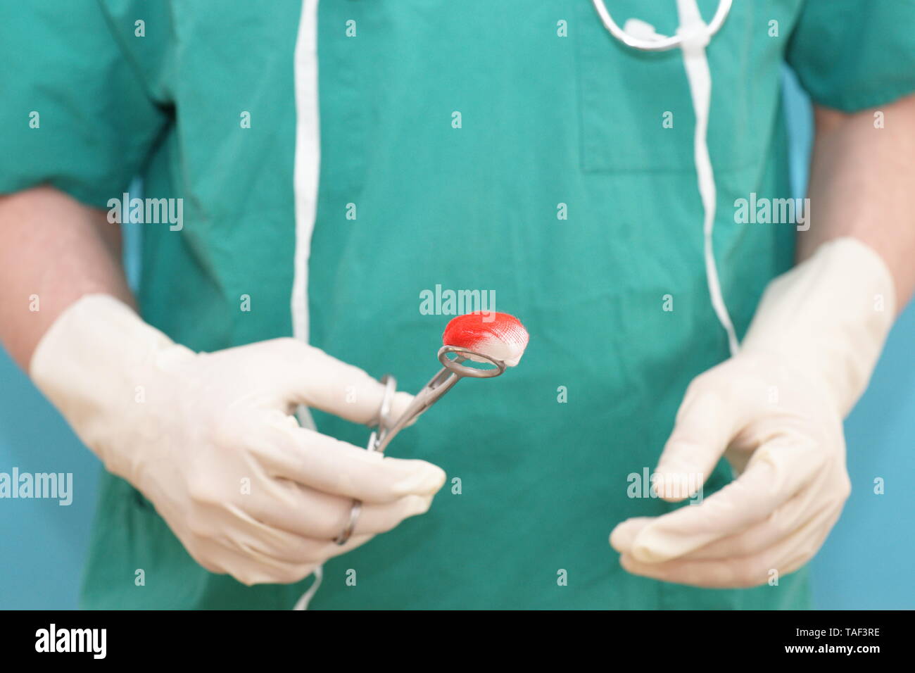 Close-up de l'homme médecin chirurgien dans scrubs vert prend soin d'une plaie Banque D'Images