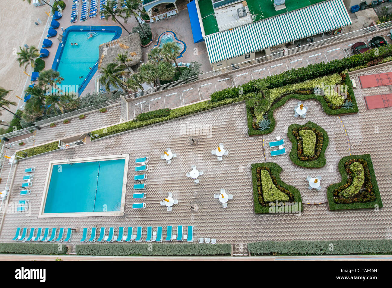 Vue aérienne de deux piscines sur des propriétés voisines par la plage en Floride du Sud. Banque D'Images