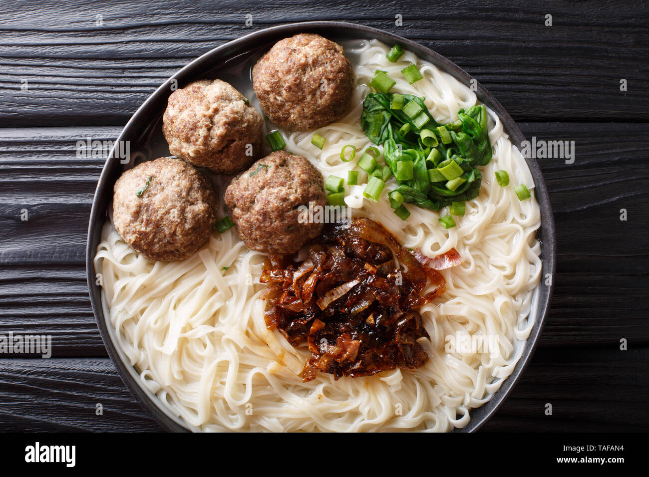 Bakso meatball indonésien est servi avec des nouilles, servi avec oignons caramélisés et les herbes sur une plaque sur la table. Vue de dessus de l'horizontale Banque D'Images