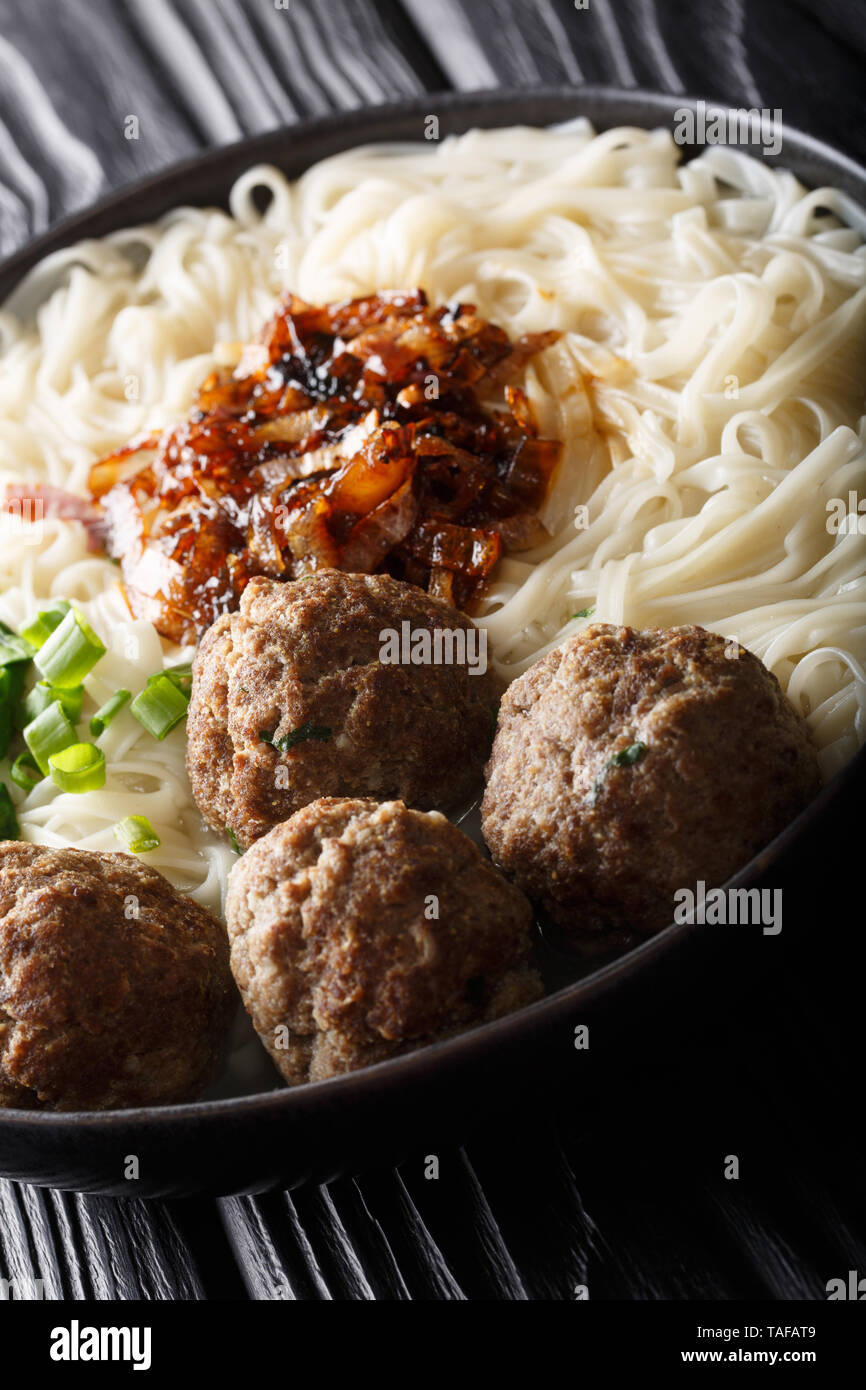 Bakso meatball indonésien est servi avec des nouilles, servi avec oignons caramélisés et les herbes sur une plaque verticale sur la table. Banque D'Images