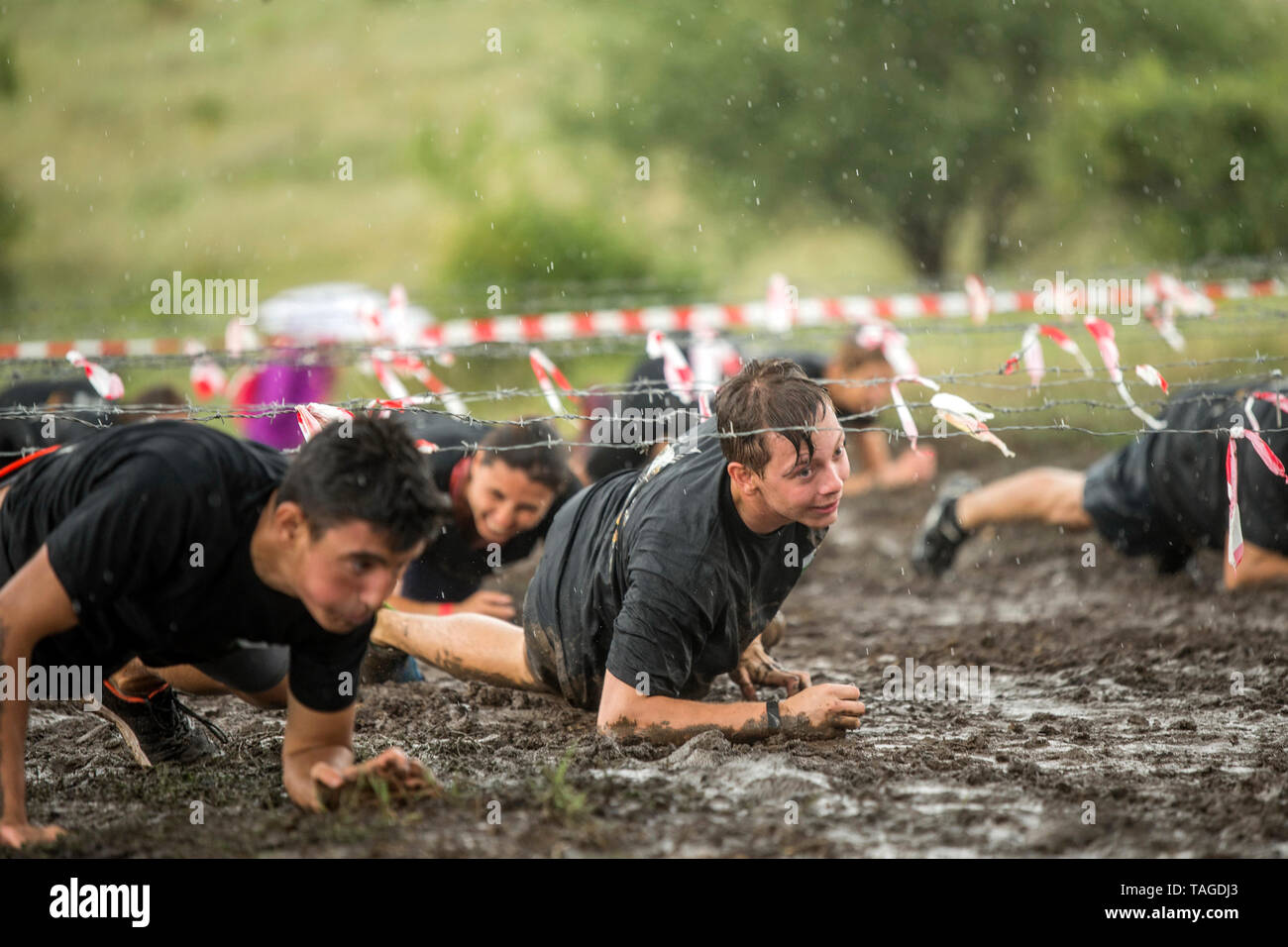 SOFIA, BULGARIE - 7 juillet 2018 : hommes ramper sous les barbelés pour surmonter les obstacles dans une course de boue Banque D'Images