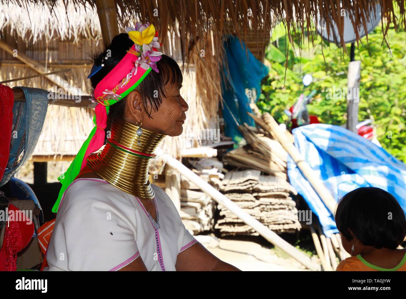 Baidjan KAREN VILLAGE, THAÏLANDE - 17 décembre. 2017 : de vieux long cou femme assise en face d'une cabane en bambou avec un toit de chaume Banque D'Images